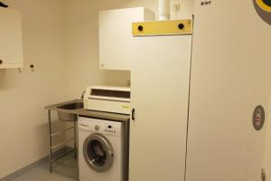 a kitchen with a washing machine and a microwave at Modern villa i Arild med spektakulär havsutsikt. in Arild