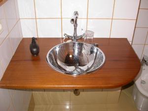 a bathroom sink with a faucet on a wooden counter at Casa de Alba in San Martín de Oscos