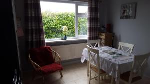 a dining room with a table and chairs and a window at Pauleens Peaceful Place in Rochfortbridge