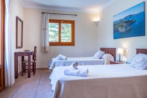 pokój hotelowy z dwoma łóżkami i stołem w obiekcie Finca SON PERIS by Mallorca Villa Selection w mieście Felanitx +19 zdjęć