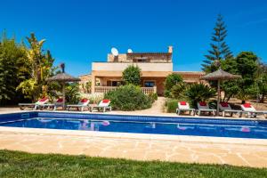 basen z leżakami i parasolami przed domem w obiekcie Finca SON PERIS by Mallorca Villa Selection w mieście Felanitx