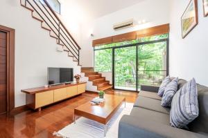 a living room with a couch and a tv at The Pig House Khao Yai - SHA Plus in Mu Si