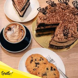 a table with plates of cakes and a cup of coffee at Yello Hotel Cebu powered by Cocotel in Cebu City