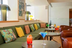 a living room with a couch and tables with drinks at Mercure Marseille Centre Prado Vélodrome in Marseille