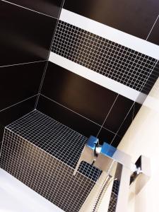 a bathroom with a black and white tiled floor at Emerald Apartament in Białystok