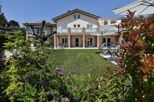 una casa grande con un patio con flores en Garda Bloom Holiday Apartments, en Padenghe sul Garda