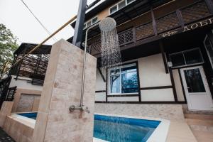 a house with a shower in front of it at Guest House Lyudmila in Feodosia