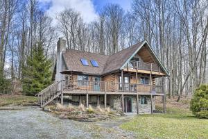une grande maison en bois avec une grande terrasse dans l'établissement Secluded Pleasant Mount Cabin with Deck and Fireplace!, à Pleasant Mount
