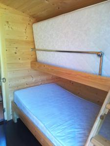 a room with two bunk beds in a wooden cabin at Imantas nams in Jūrkalne
