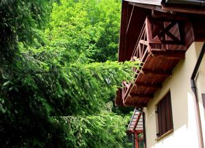 a building with green trees and a balcony at Zawoja Chaty Górskie D4 in Zawoja