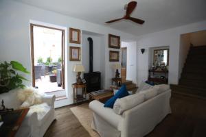 sala de estar con 2 sofás blancos y ventilador de techo en Casa Rural Miller's of Frigiliana, en Frigiliana