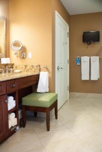 ein Badezimmer mit einem Waschbecken, einem Stuhl und einem Spiegel in der Unterkunft Ponte Vedra Inn and Club in Ponte Vedra Beach