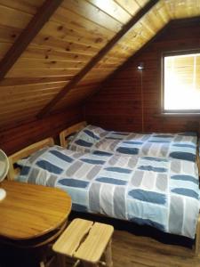 - une chambre avec un lit et une table dans une cabine dans l'établissement Viesu namiņš Dālderi, à Varakļāni