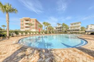 a large swimming pool with chairs and palm trees at South Walton Condos II in Inlet Beach