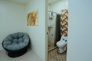 OYO 645 Ljenj Apartelle في Mabalacat: حمام به كرسي ازرق ومرحاض