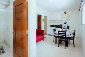 a kitchen and dining room with a red chair and a table at OYO 645 Ljenj Apartelle in Mabalacat