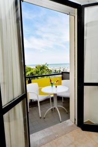 a balcony with a table and a view of the ocean at Hotel Mimosa in Riccione