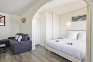 a bedroom with a bed and a couch at Studio Arché - Welkeys in Biarritz