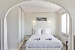 a bedroom with a white bed with an archway at Studio Arché - Welkeys in Biarritz
