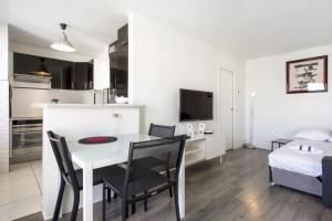 a kitchen and living room with a table and chairs at Studio Arché - Welkeys in Biarritz