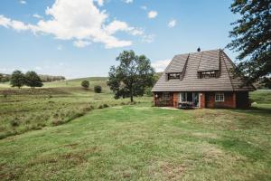 a house in the middle of a field at Valley Lakes CHALETS in Underberg