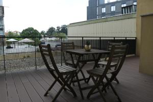 a table and chairs on a deck with a fence at Metro Heroismo Residence in Porto