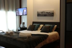 a bedroom with a bed with a tv on the wall at Metro Heroismo Residence in Porto