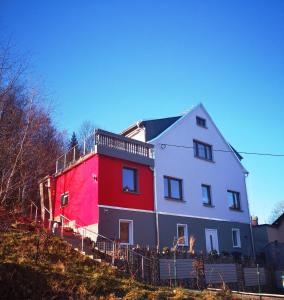 una casa roja y blanca en la cima de una colina en Ferienhaus am Waldbad Brunn en Brunn