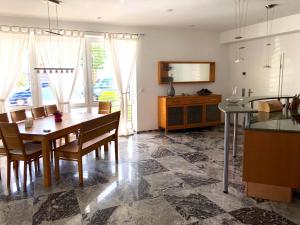 a kitchen and dining room with a table and chairs at Dreamapartment La Vigna Living mit eigenem Aussenpool & Sauna - Weil am Rhein in Weil am Rhein