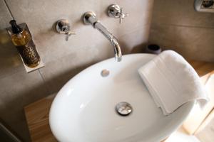 lavabo blanco en el baño con una botella de jabón en Al Solìf, en Livigno