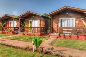 une rangée de cottages en bois dans un complexe dans l'établissement Bliss Water Resort, à Arambol