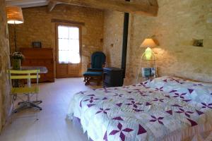 1 dormitorio con cama, mesa y ventana en Chambres d'hôtes de la Grande Combe, en Mauzac-et-Grand-Castang