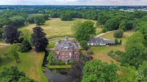 an aerial view of a large house with a lake at Hotel Kasteel Hoekelum in Bennekom
