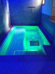 a large swimming pool with green lights in it at Relais San Giusto in Campitello di Fassa