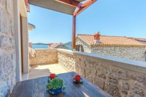 una mesa en un balcón con vistas al agua en House Stone house island Prvic, en Prvić Šepurine