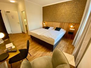 a hotel room with a bed and a desk and chairs at Hotel Deutsches Haus in Kitzingen