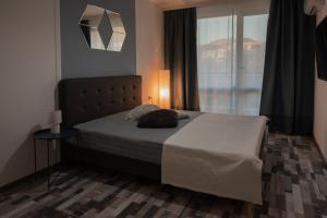 a bedroom with a bed and a large window at SOS CoMFORT in Burgas