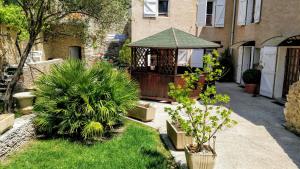 un jardín con cenador y algunas plantas en Mas des Coccinelles, en Mollans-sur-Ouvèze