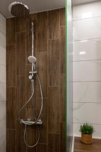 a shower in a bathroom with wooden tiles at SOS CoMFORT in Burgas City