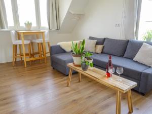 ein Wohnzimmer mit einem blauen Sofa und einem Tisch in der Unterkunft Bed and Breakfast Maas en Waal in Winssen