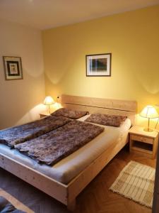 2 camas en una habitación con paredes amarillas y 2 lámparas en Apartment Furschermuehle, en Siusi
