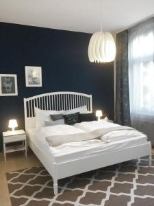 Un dormitorio con una cama blanca y una pared azul. en Römerburg Apartments Burgstraße, en Boppard