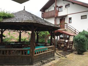 Un mirador con mesas y sillas frente a un edificio. en Pensiunea Iona, en Baia Mare