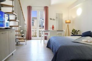 a bedroom with a bed and a table and a balcony at Il Faro appartamenti in San Vincenzo