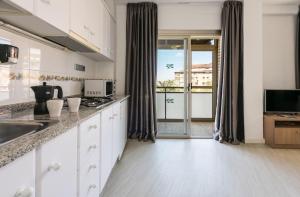a kitchen with a sink, stove and refrigerator at Flats Friends Atlantida in Benidorm