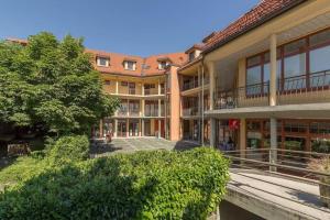 un immeuble d'appartements avec une cour et un arbre dans l'établissement Apartment Center, à Bled
