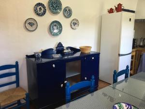 uma cozinha com um armário azul e pratos na parede em Casa La Dehesa em Huertas Bajas