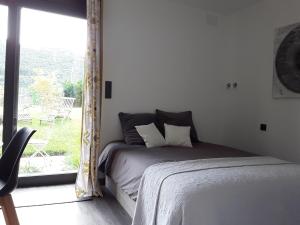 a bedroom with a bed and a large window at Castro Eco 10 in Castro-Urdiales