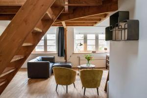 a living room with a couch and chairs at Spoorzicht Long Stay Apartments in Loppersum