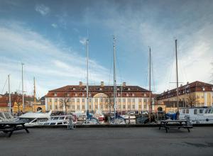 Un puerto deportivo con barcos estacionados frente a un edificio. en Kanalhuset, en Copenhague